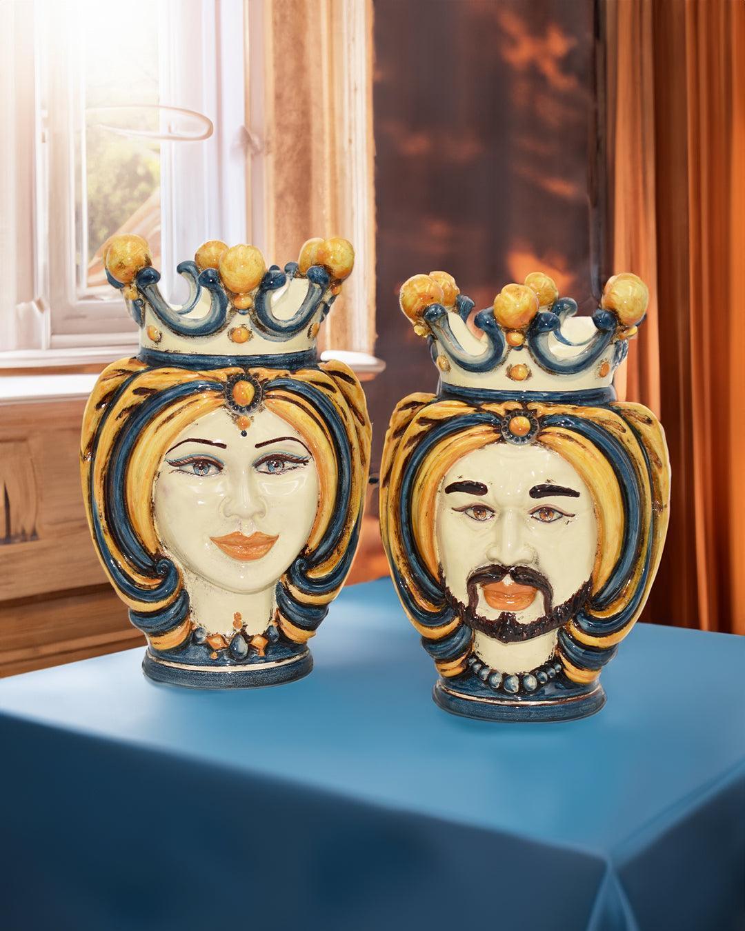 Hand-painted ceramic Teste di Moro vases with crowns in blue and orange on a table indoors.