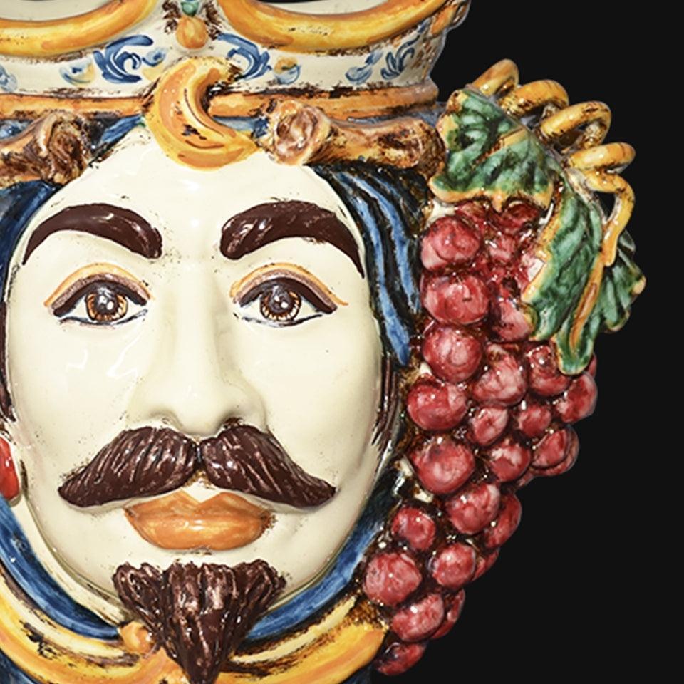 Ceramiche di Caltagirone fatti a mano con volto e grappolo d'uva, arte tradizionale siciliana