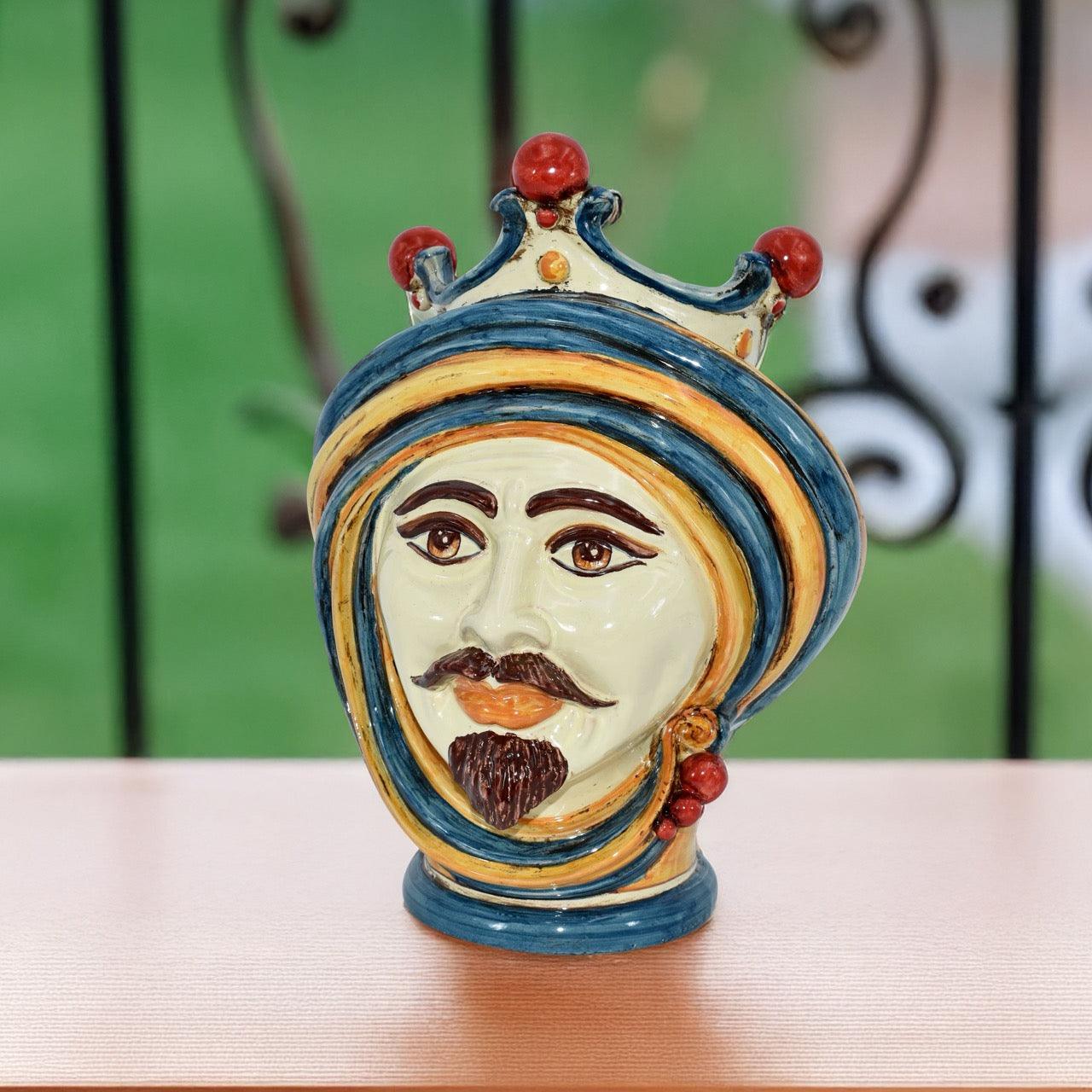 Handcrafted ceramic Testa di Moro male head with blue and orange details on table
