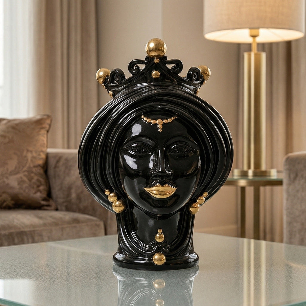 Black and gold Teste di Moro ceramic sculpture with crown, displayed on glass table in modern living room