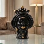 Black and gold Teste di Moro ceramic sculpture with crown, displayed on glass table in modern living room