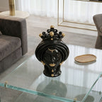 Black and gold Teste di Moro ceramic head sculpture with crown, displayed on glass table in modern living room