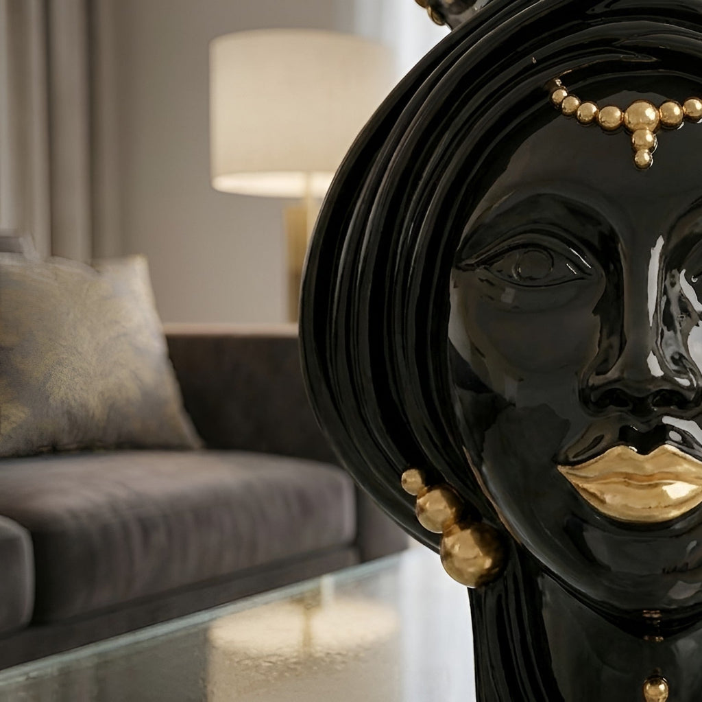 Black ceramic Teste di Moro with gold lips and beads, modern home decor on glass table