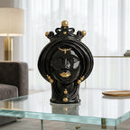 Black and gold Teste di Moro decorative head sculpture with crown, displayed on glass table in modern living room