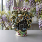 Handmade Teste di Moro ceramic vase with Medusa snake hair, purple berries, and green leaves, perfect home decor.
