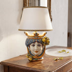 Handmade Sicilian Testa di Moro table lamp with colorful ceramic face, crown, and lemons, on wooden side table