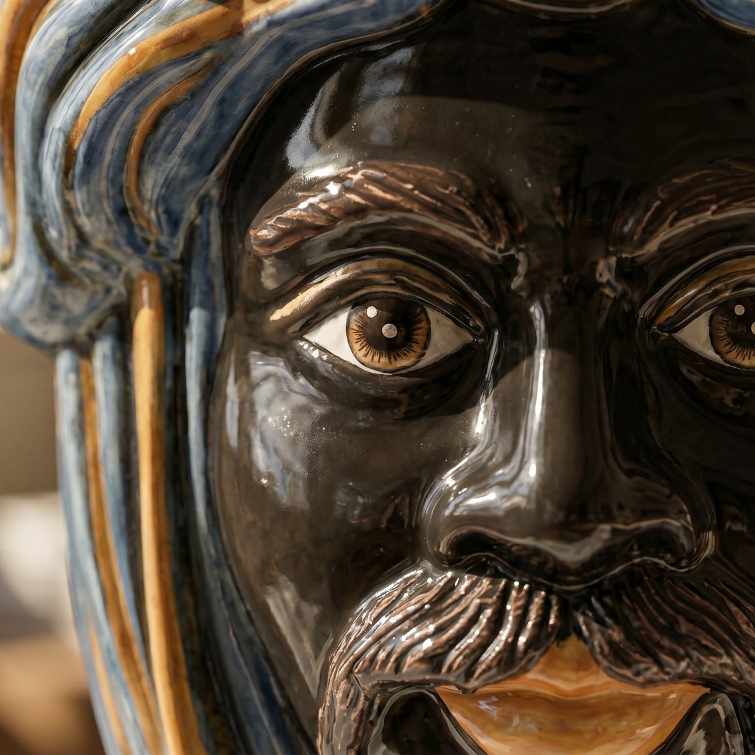 Handcrafted Teste di Moro ceramic face with glazed blue and gold details, showcasing artisanal Sicilian design.