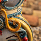 Handcrafted Teste di Moro ceramic with vibrant blue, yellow, and red swirls, showcasing traditional Sicilian artistry.