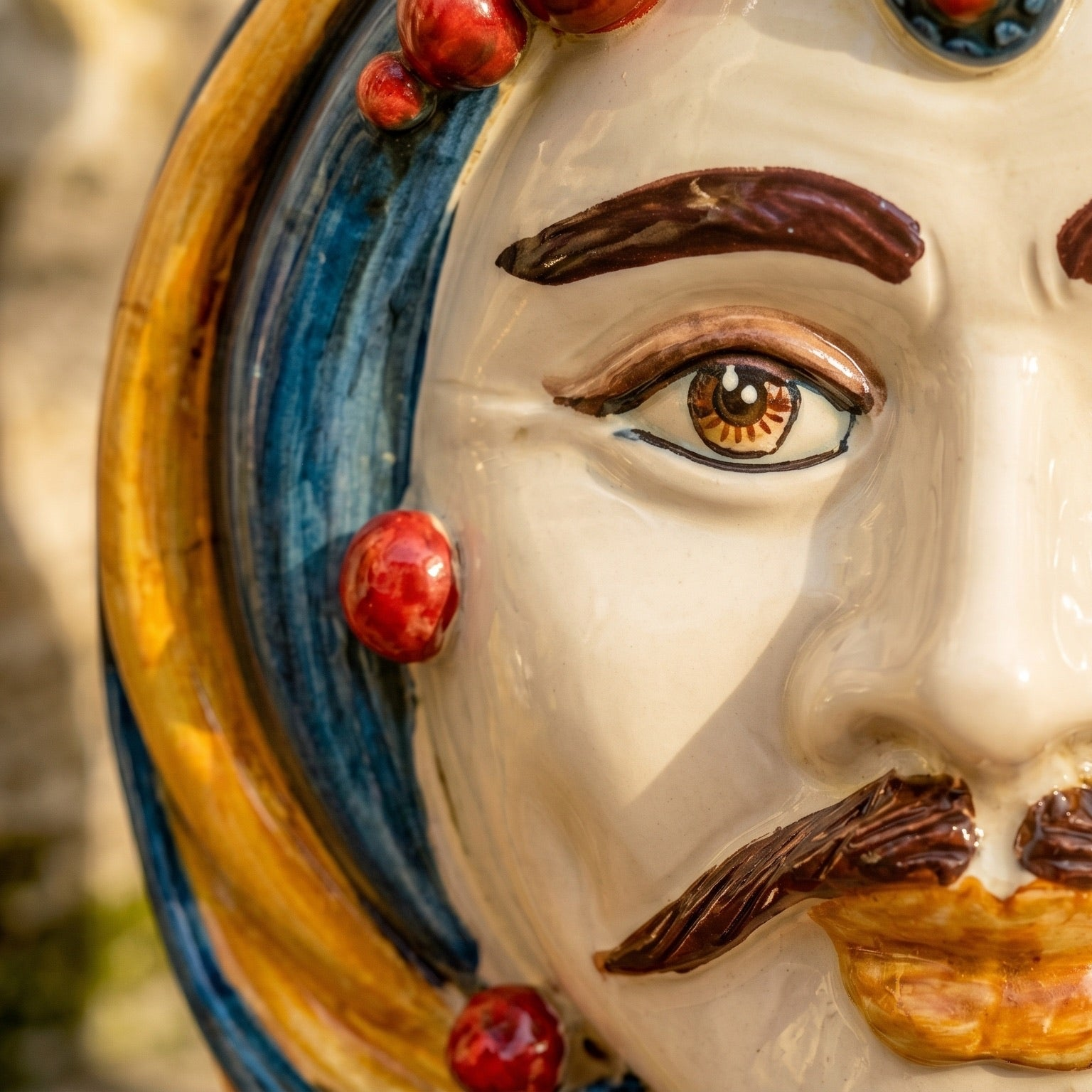 Handcrafted Teste di Moro ceramic face with vibrant blue and gold details, traditional Sicilian art