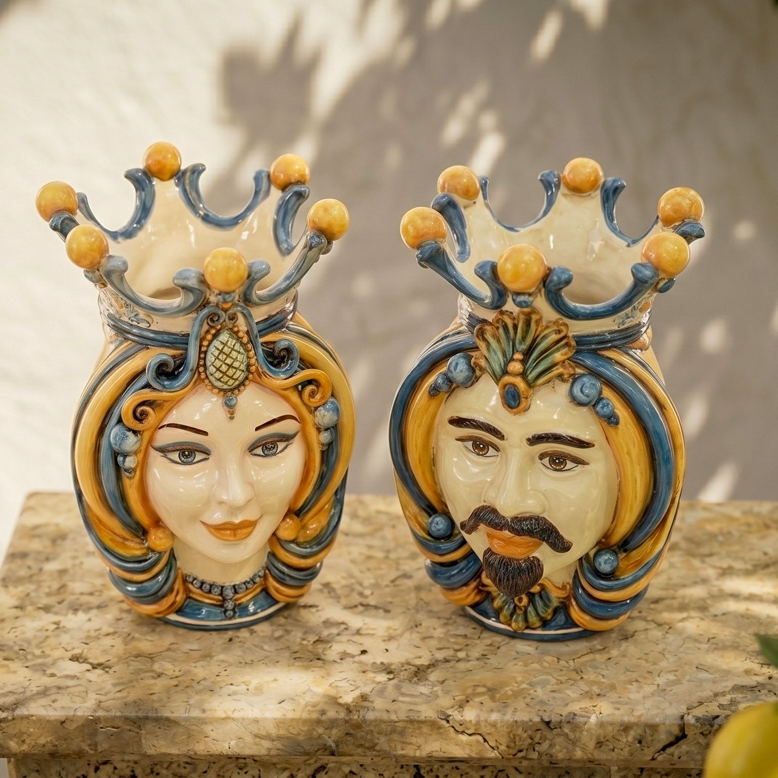 Handcrafted Teste di Moro ceramic vases with crowned male and female faces, vibrant blue and gold details, perfect for home decor.