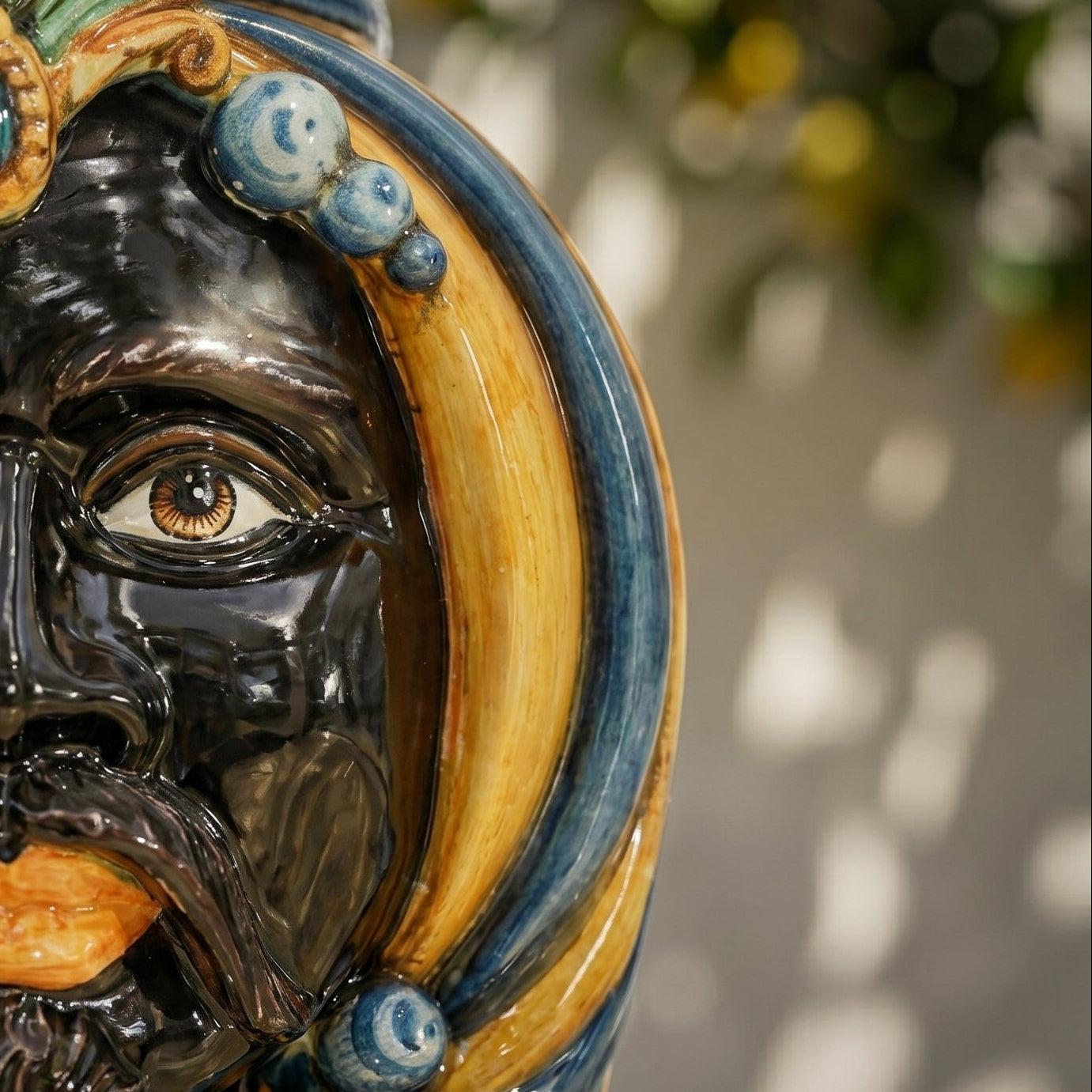 Handcrafted Teste di Moro ceramic face with glossy black finish, blue and gold accents, and detailed eye