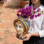 Hand-painted Teste di Moro vase with vibrant purple flowers, showcasing traditional Sicilian ceramic artistry.