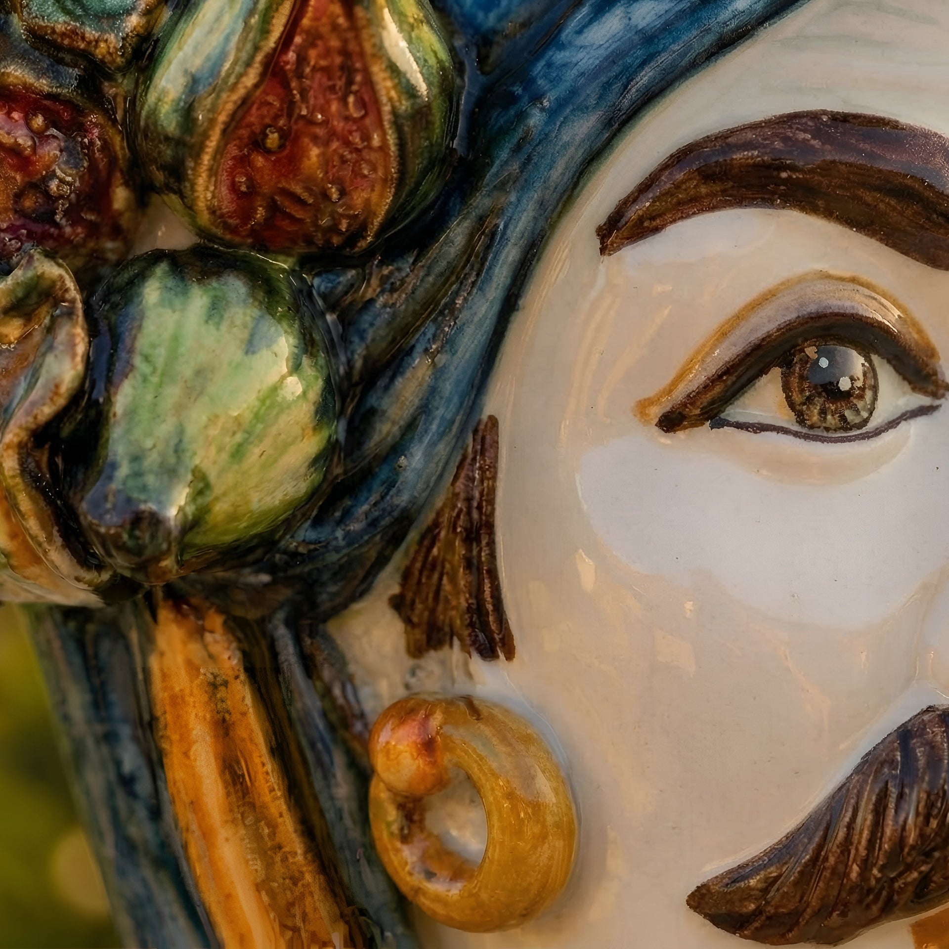 Close-up of a handcrafted Teste di Moro ceramic face with vibrant glazed details and expressive eye.