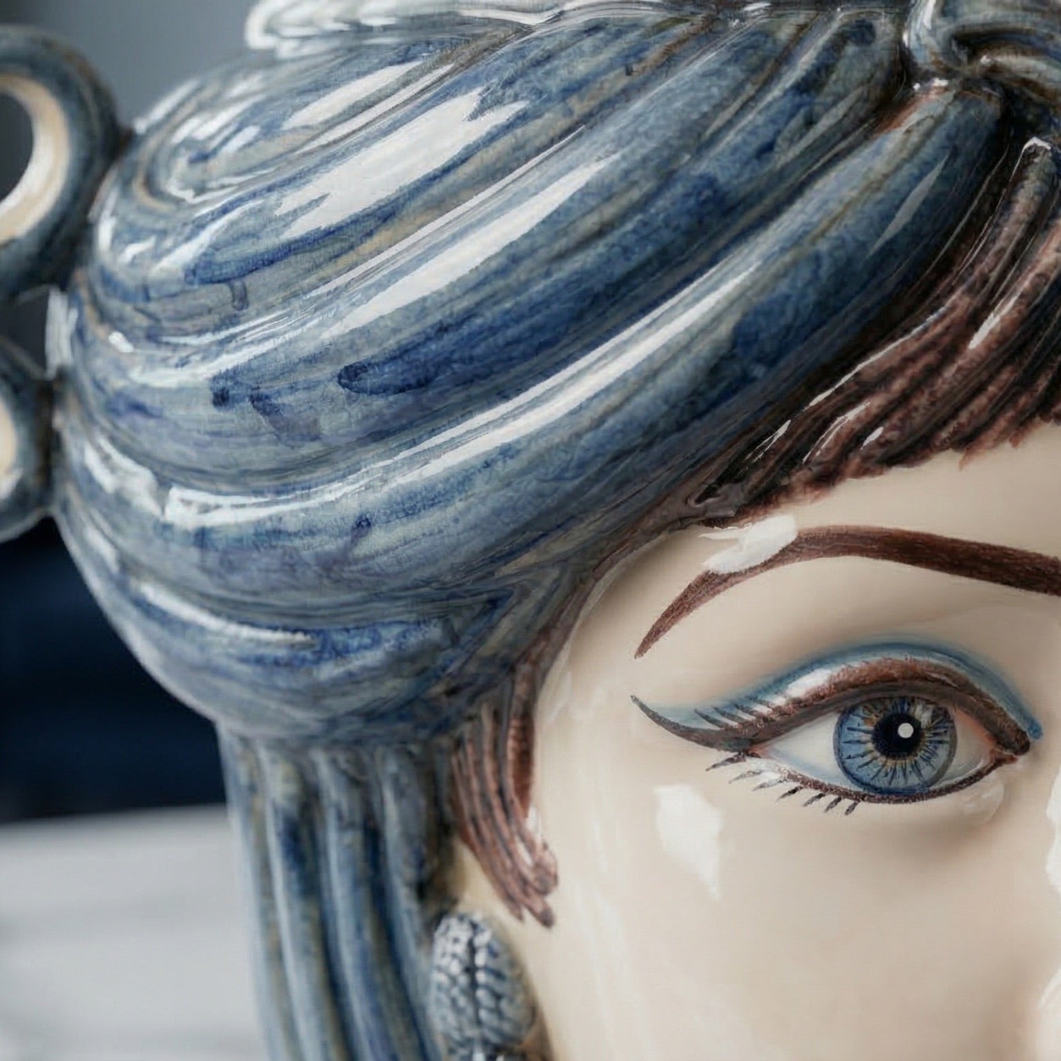 Handcrafted Teste di Moro ceramic with blue-swirled hair and detailed eye, blending tradition and modern design.