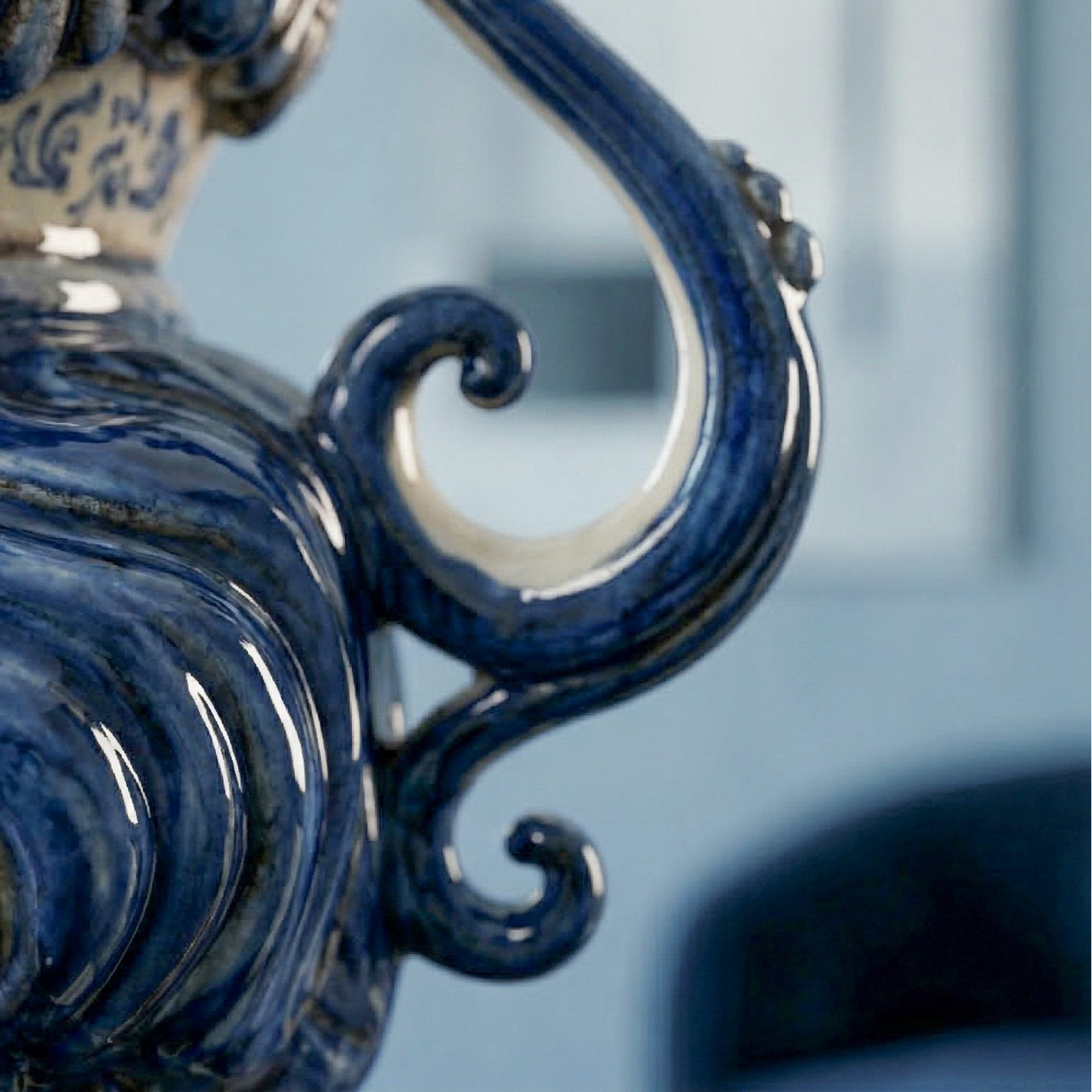 Handcrafted blue ceramic Teste di Moro with ornate scroll handle, blending tradition and modern design.