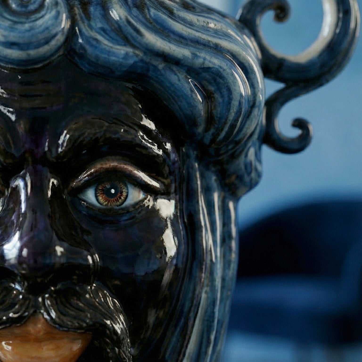Handmade Teste di Moro ceramic with glossy dark glaze, detailed eye, and swirling hair design