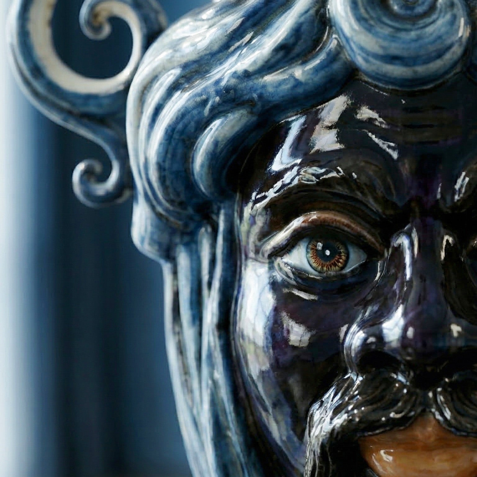 Handcrafted Teste di Moro ceramic with glossy blue glaze, detailed eye, and swirling hair design