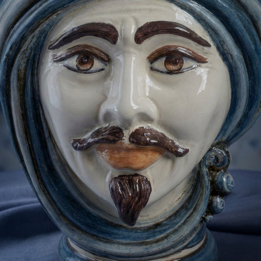 Handmade ceramic Testa di Moro with blue turban, expressive eyes, and mustache, blending tradition and modern design.