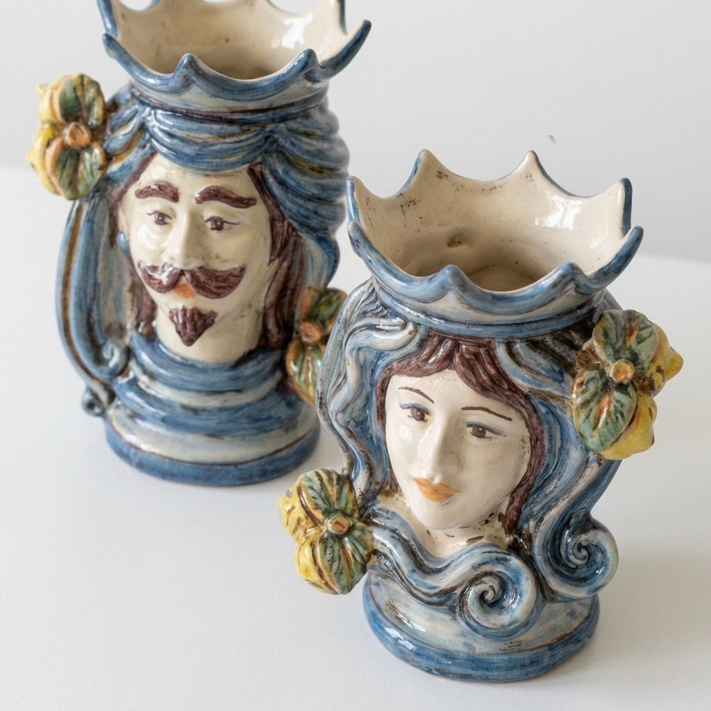 Handmade Teste di Moro ceramic vases with blue swirls, floral accents, and expressive faces, blending tradition and modern design.
