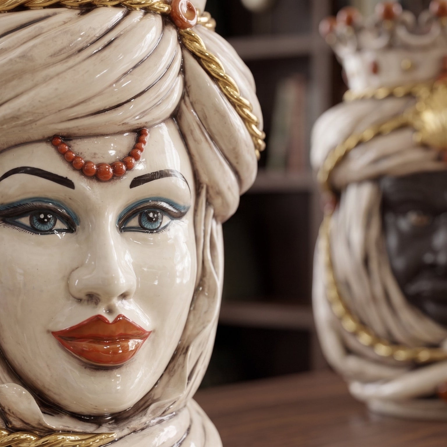 Handmade Teste di Moro ceramic sculpture with detailed turban, blue eyes, and coral beads, blending tradition and modern design.