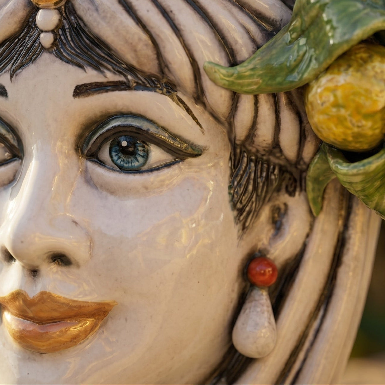 Handcrafted Teste di Moro ceramic face with blue eyes, gold lips, and citrus leaf detail