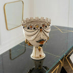 Handmade Teste di Moro ceramic vase with floral crown, mustache, and gold accents on marble table