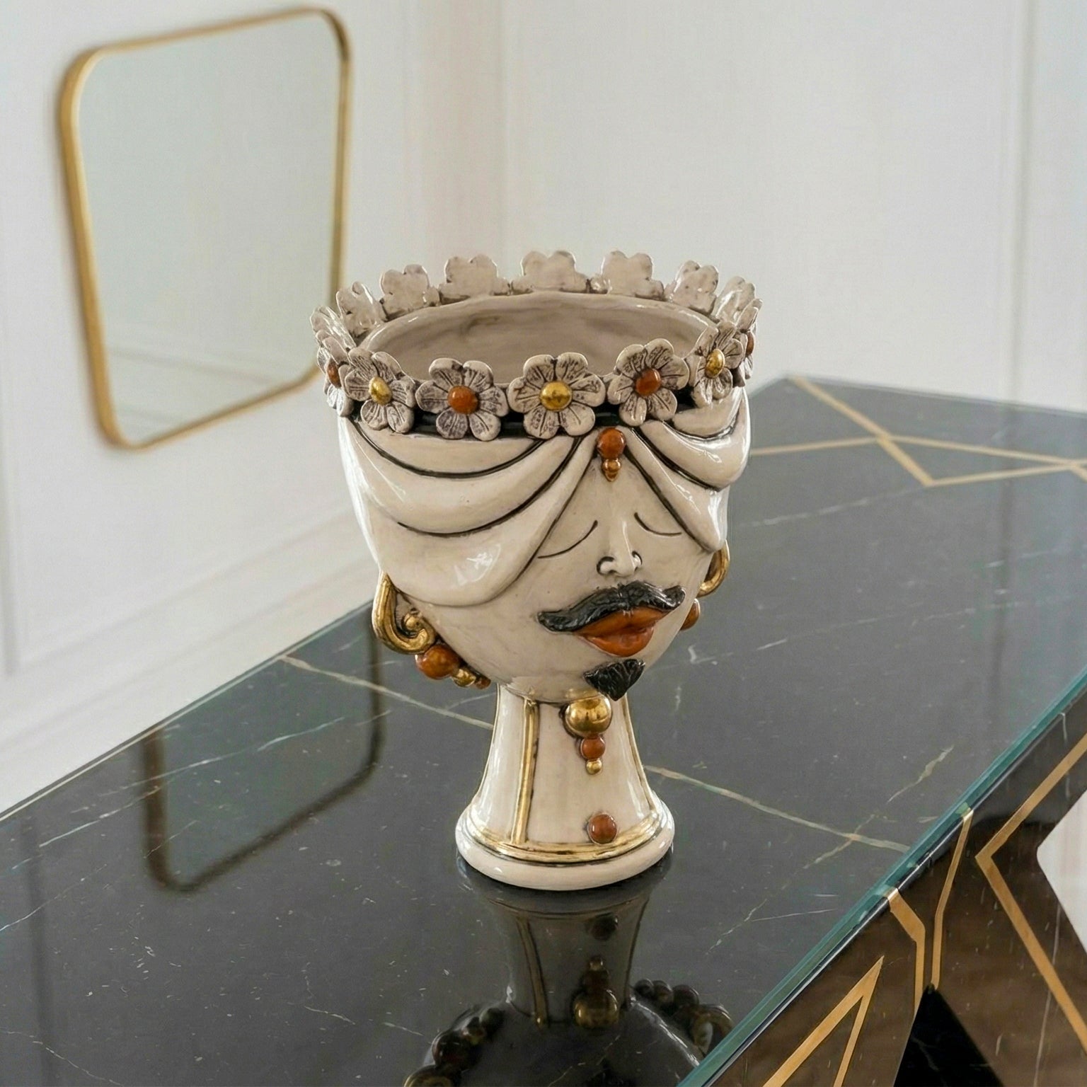 Handmade Teste di Moro ceramic vase with floral crown, mustache, and gold accents on marble table