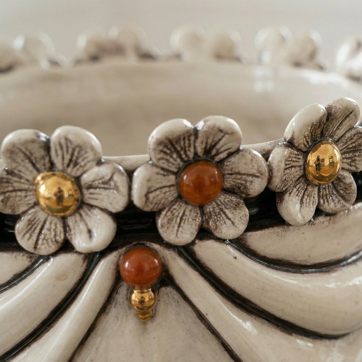 Handcrafted ceramic vase with floral details, gold and amber accents, blending tradition and modern design