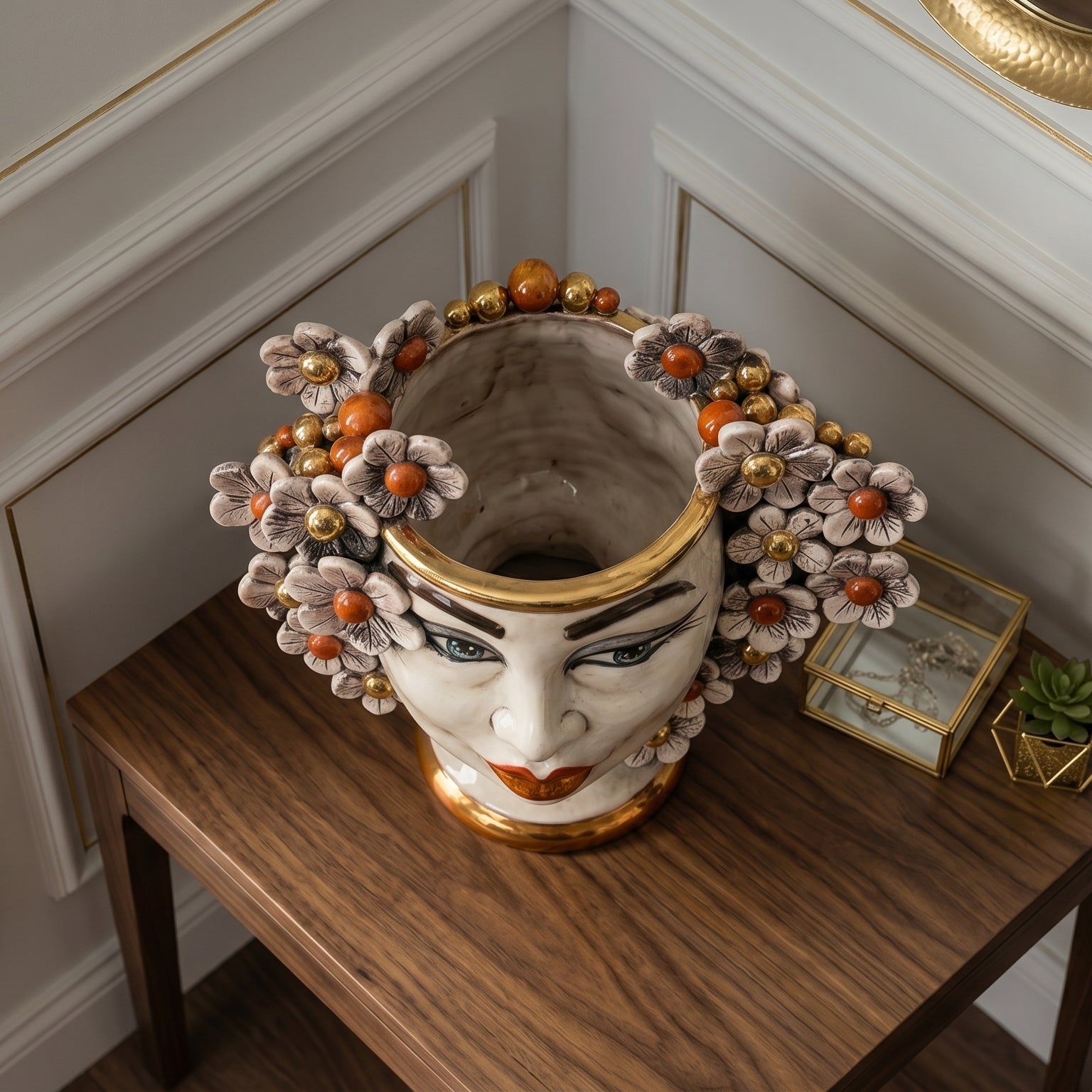 Handcrafted Teste di Moro vase with floral crown, gold accents, and expressive face, displayed on wooden table.