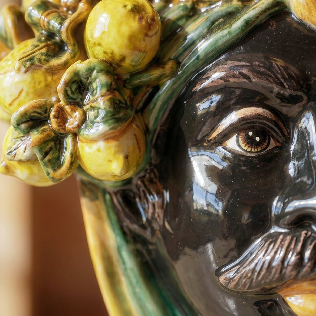Handcrafted Teste di Moro ceramic with vibrant yellow lemons and green leaves, showcasing detailed facial features.