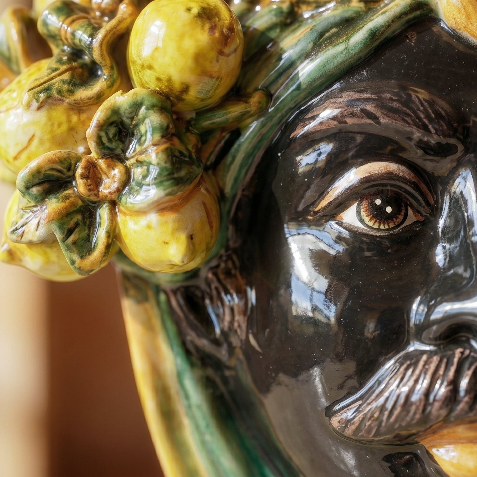 Handcrafted Teste di Moro ceramic with vibrant yellow lemons and green leaves, showcasing detailed facial features.
