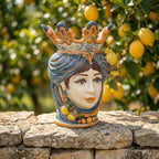 Handcrafted Sicilian Testa di Moro ceramic vase with crown, lemon accents, set outdoors on stone wall