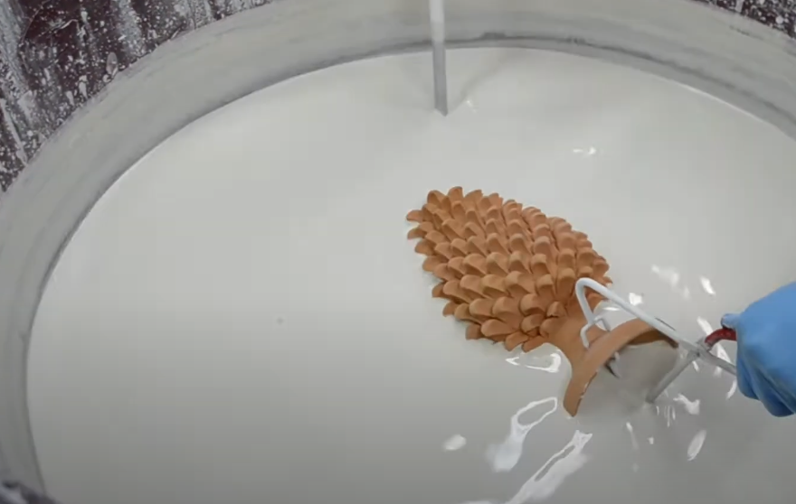 Handcrafted Teste di Moro ceramic being glazed in white slip, showcasing traditional Sicilian artistry.