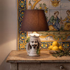 Handmade ceramic Teste di Moro lamp with mustache, lemon accents, and brown shade on rustic table