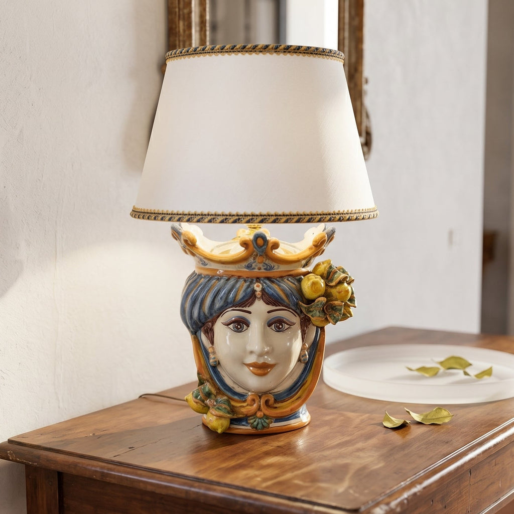 Handcrafted Sicilian Testa di Moro table lamp with colorful ceramic face, lemon accents, and white shade on wood surface