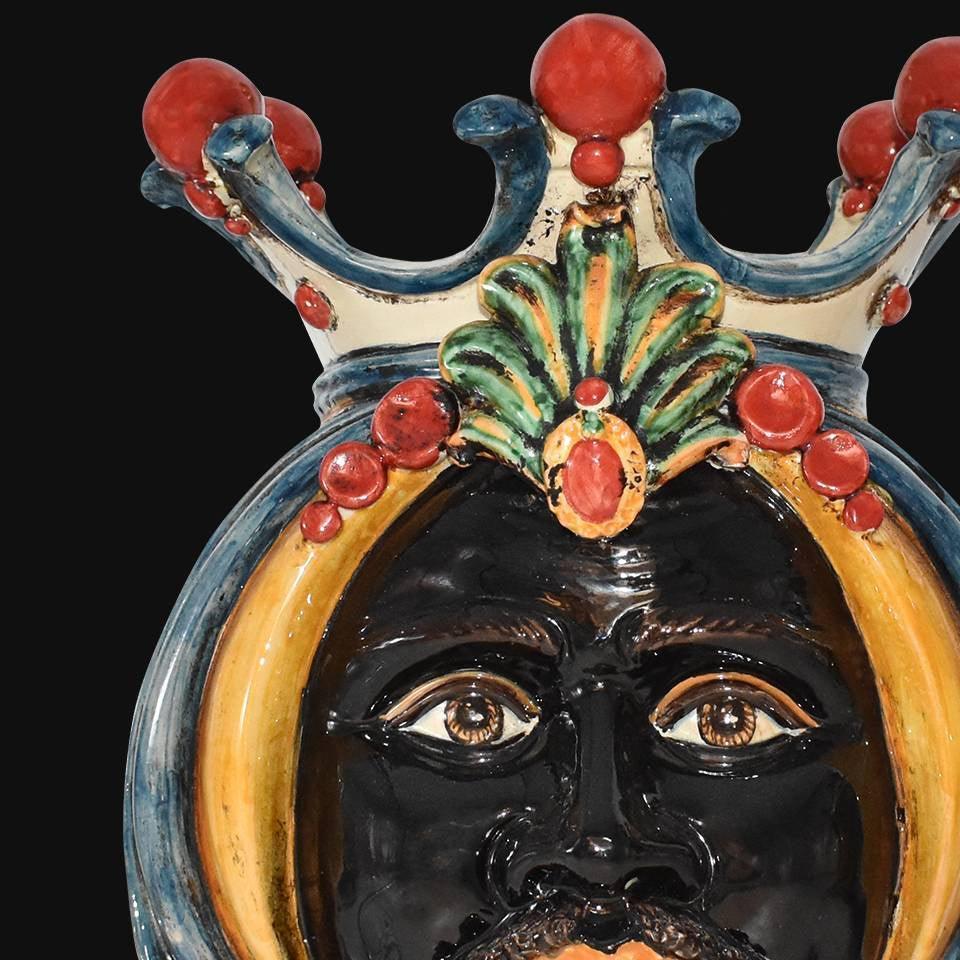 Handmade ceramic Moro head in blue, orange, and green with ornate crown detail