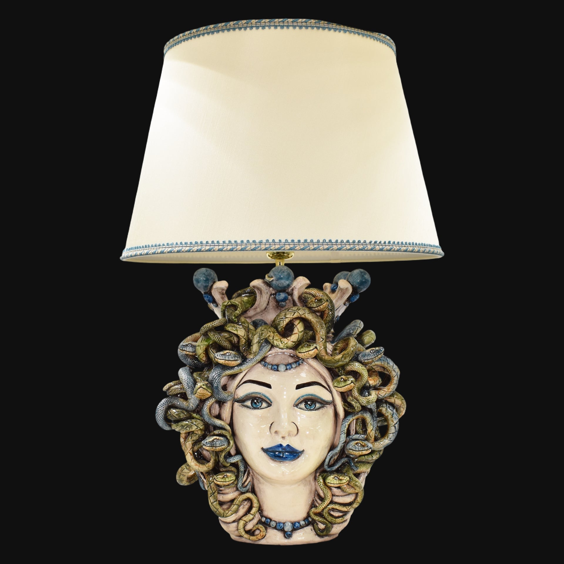 Handmade Medusa head table lamp with snake hair, blue accents, and cream shade, blending tradition and modern design.