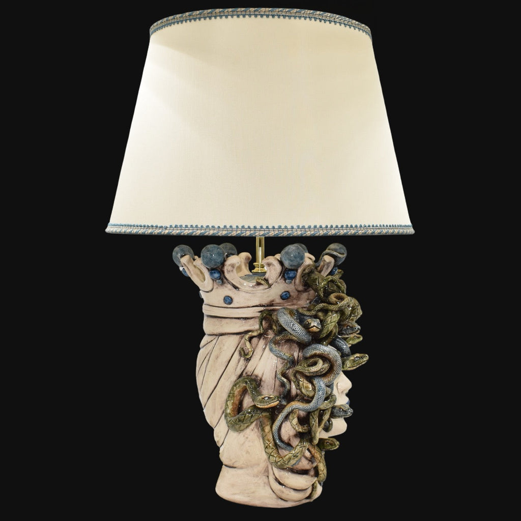 Handcrafted Medusa head table lamp with snake details and cream shade, blending tradition and modern design.