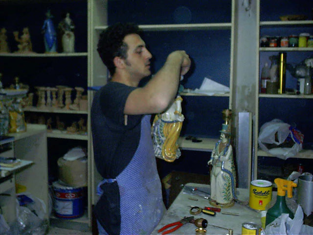 Artisan crafting handmade Teste di Moro ceramic, blending tradition with modern design in workshop