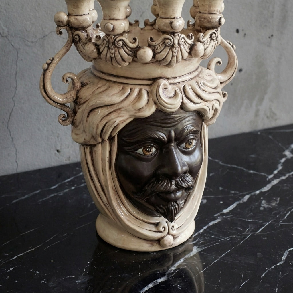 Handcrafted Teste di Moro candle holder with ornate crown, dark face, and curly hair on marble surface