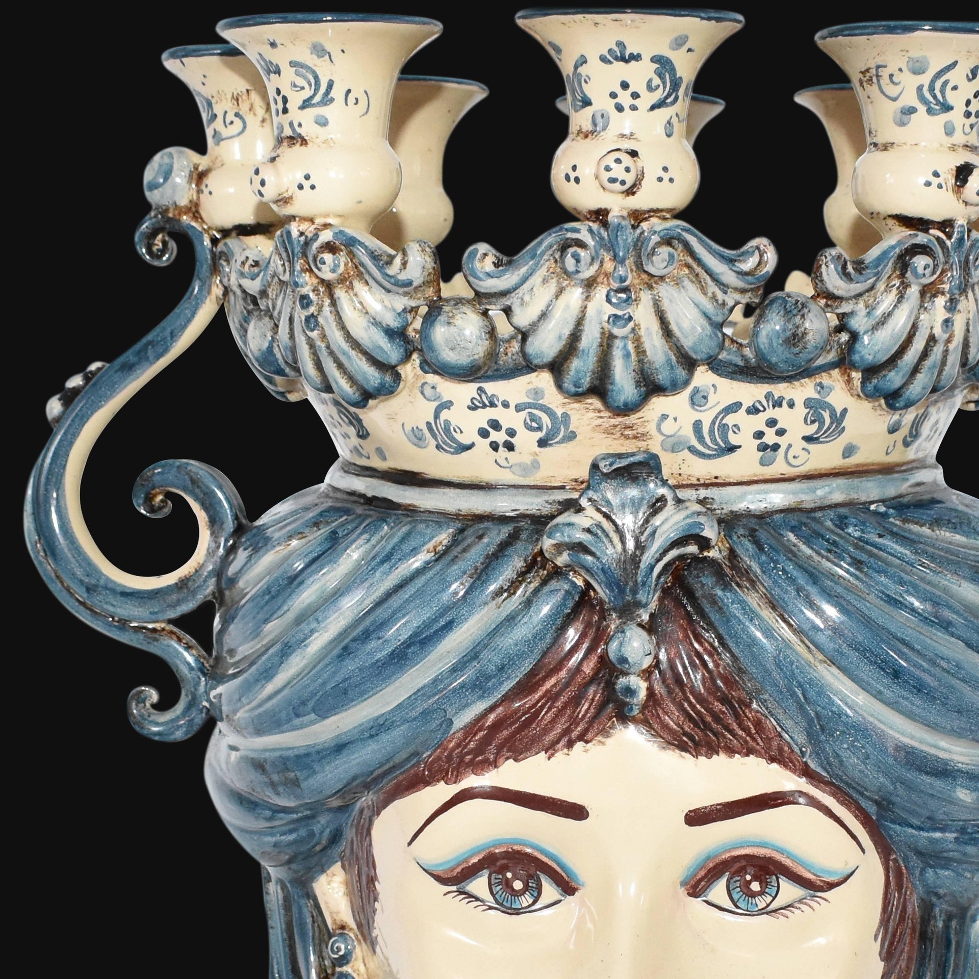 Handmade Teste di Moro ceramic candelabra with blue and cream floral details, ornate crown, and expressive eyes.