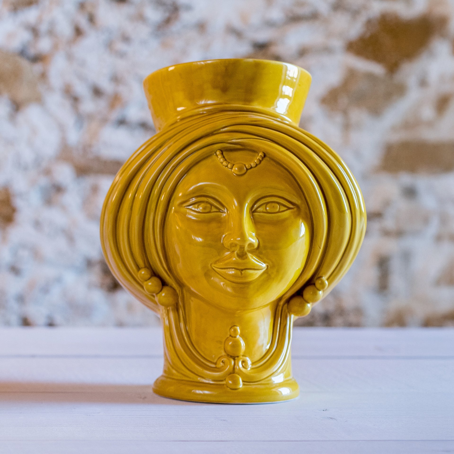 Yellow ceramic Testa di Moro woman head sculpture on wooden table, modern Caltagirone style