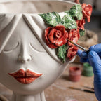 Hand-painted Teste di Moro ceramic with red roses and green leaves, artisan crafting detail