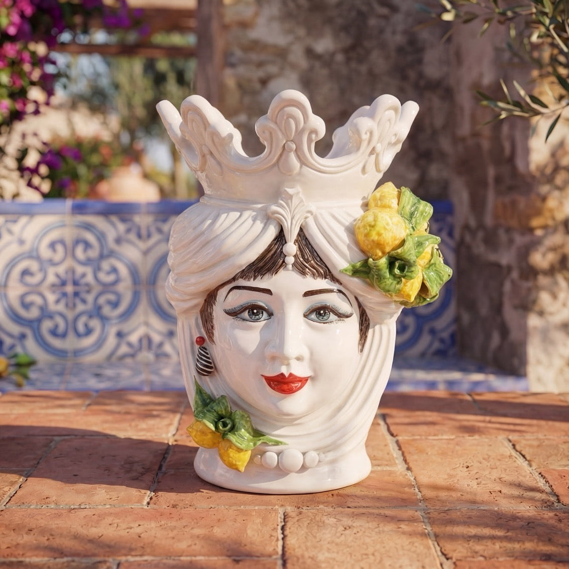 Handcrafted Teste di Moro ceramic vase with crown, lemons, and blue tile background, blending tradition and modern design.