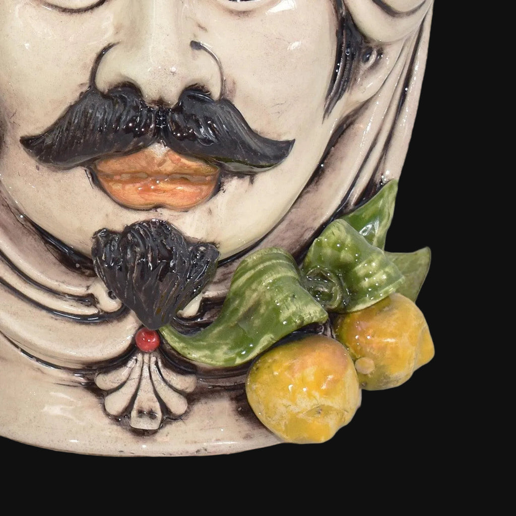 Handmade Teste di Moro ceramic with mustache, citrus fruit, and green leaves, traditional Sicilian decor