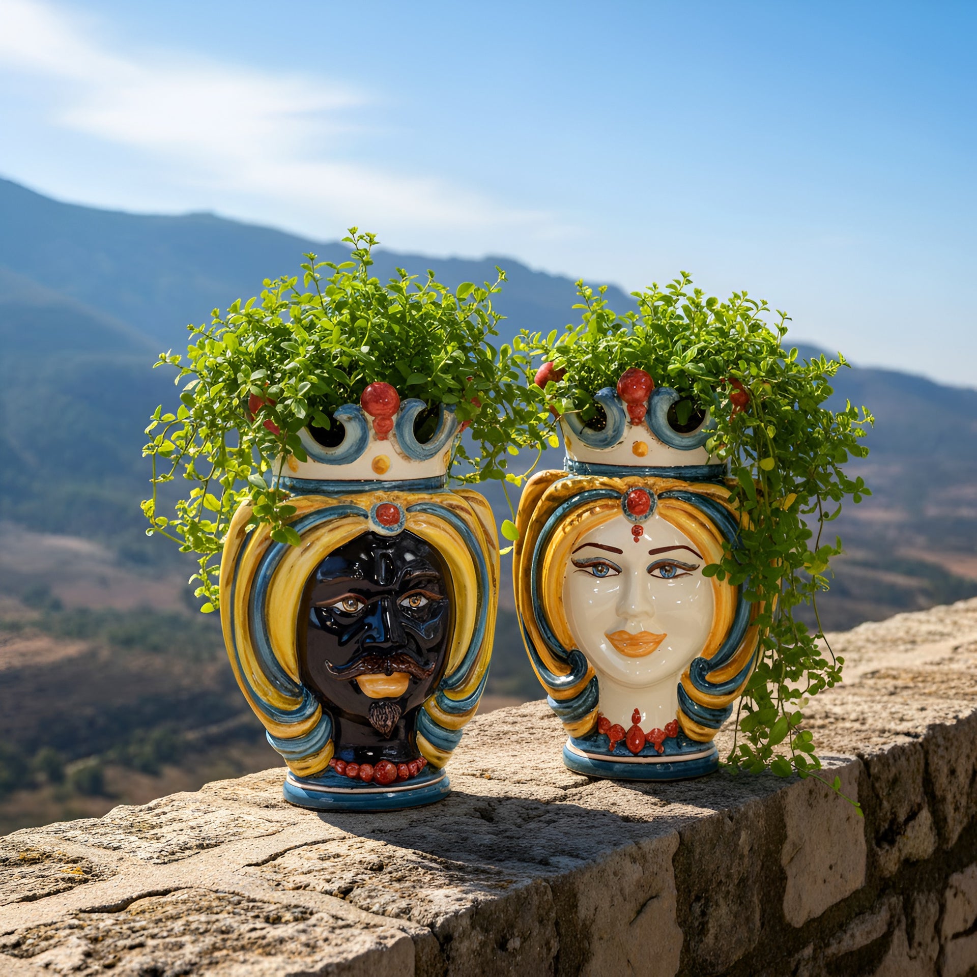 Handmade Teste di Moro planters with vibrant faces, lush greenery, set against scenic hills—perfect Sicilian decor.