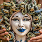 Handcrafted Teste di Moro ceramic with snake-adorned Medusa face, vibrant blue lips, traditional Sicilian art