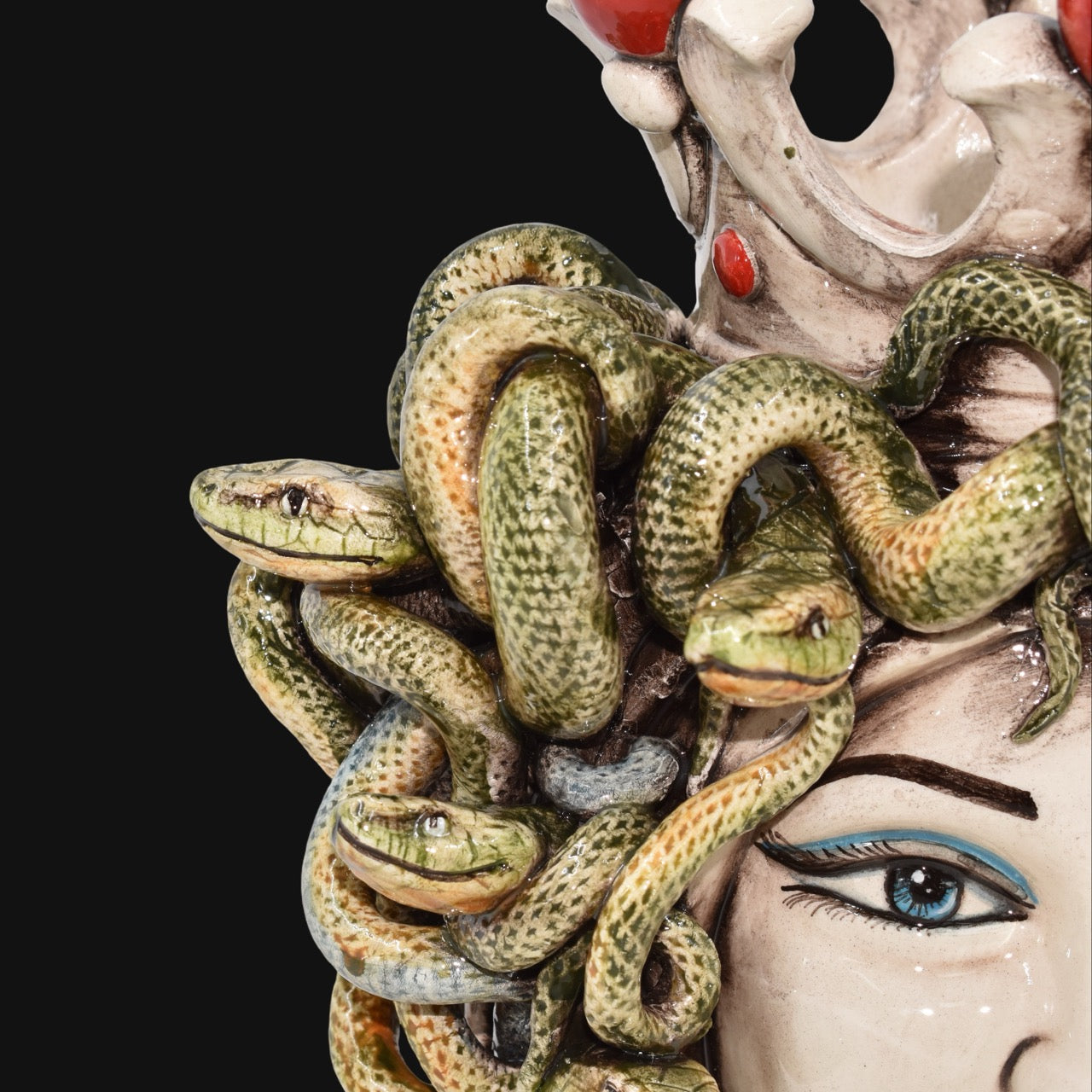 Handcrafted Teste di Moro with intricate green snakes and vibrant blue eyes, blending tradition and modern design.