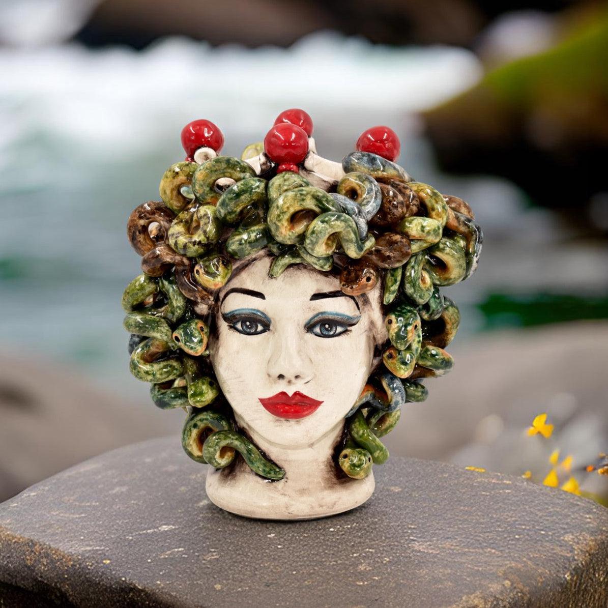 Ceramic Testa di Moro Medusa head with colorful snakes and red accents, outdoor setting
