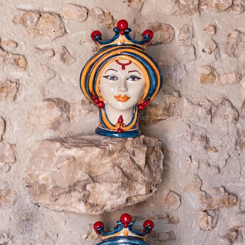 Handmade Sicilian Testa di Moro female ceramic head in blue and orange on stone wall